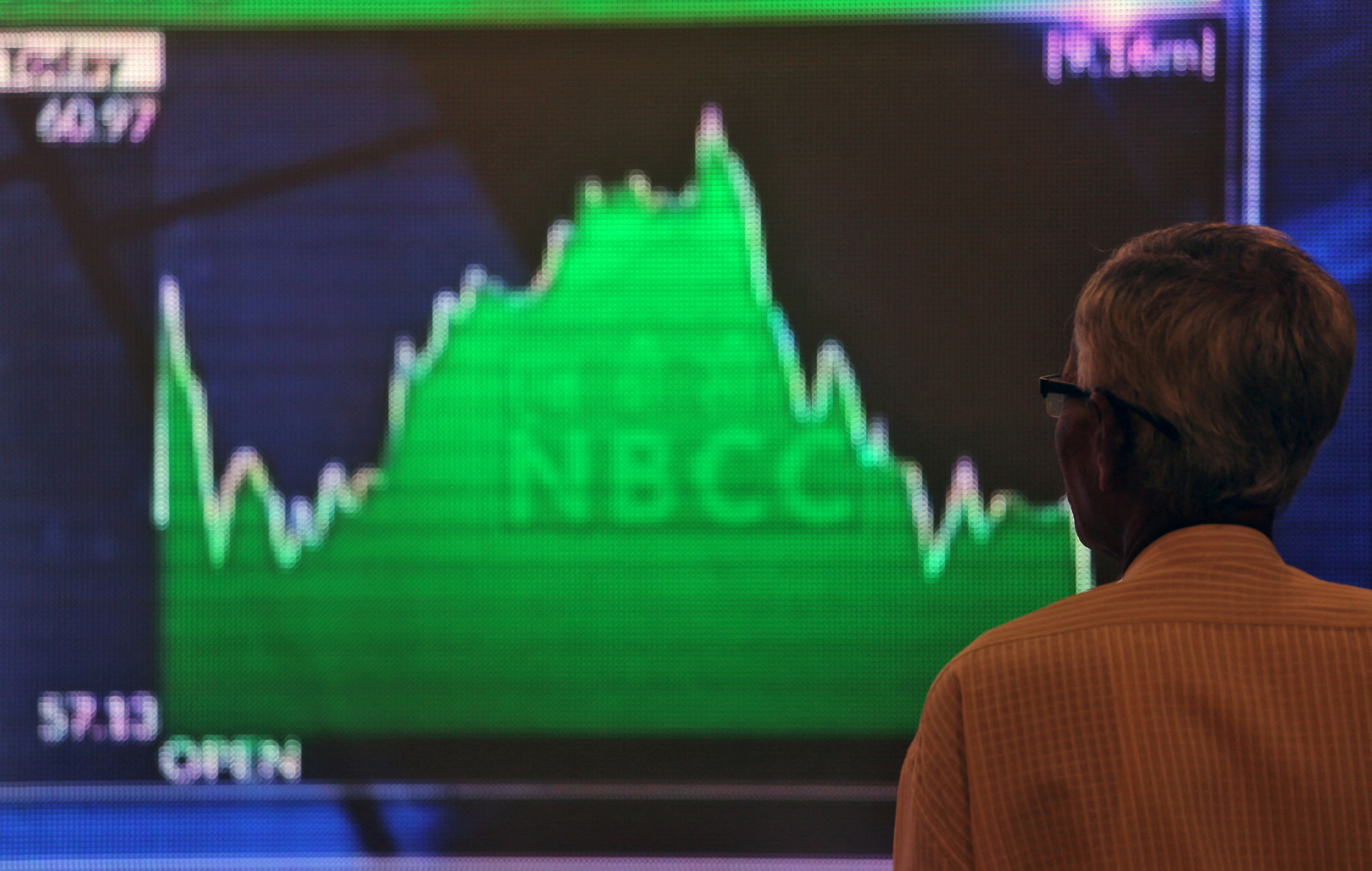 FILE PHOTO: A man looks at a screen displaying news of markets update inside the Bombay Stock Exchange (BSE) building in Mumbai, India, May 23, 2019. REUTERS/Francis Mascarenhas/File Photo